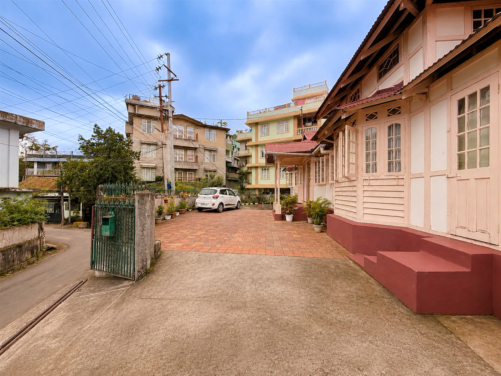 The arrival drive beside OOtO Homestay’s pink timber exterior.