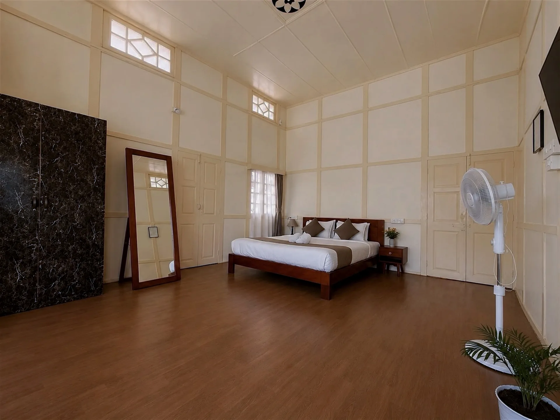 A wide view of Hometown Glory’s king bed and spacious cream-panelled room.