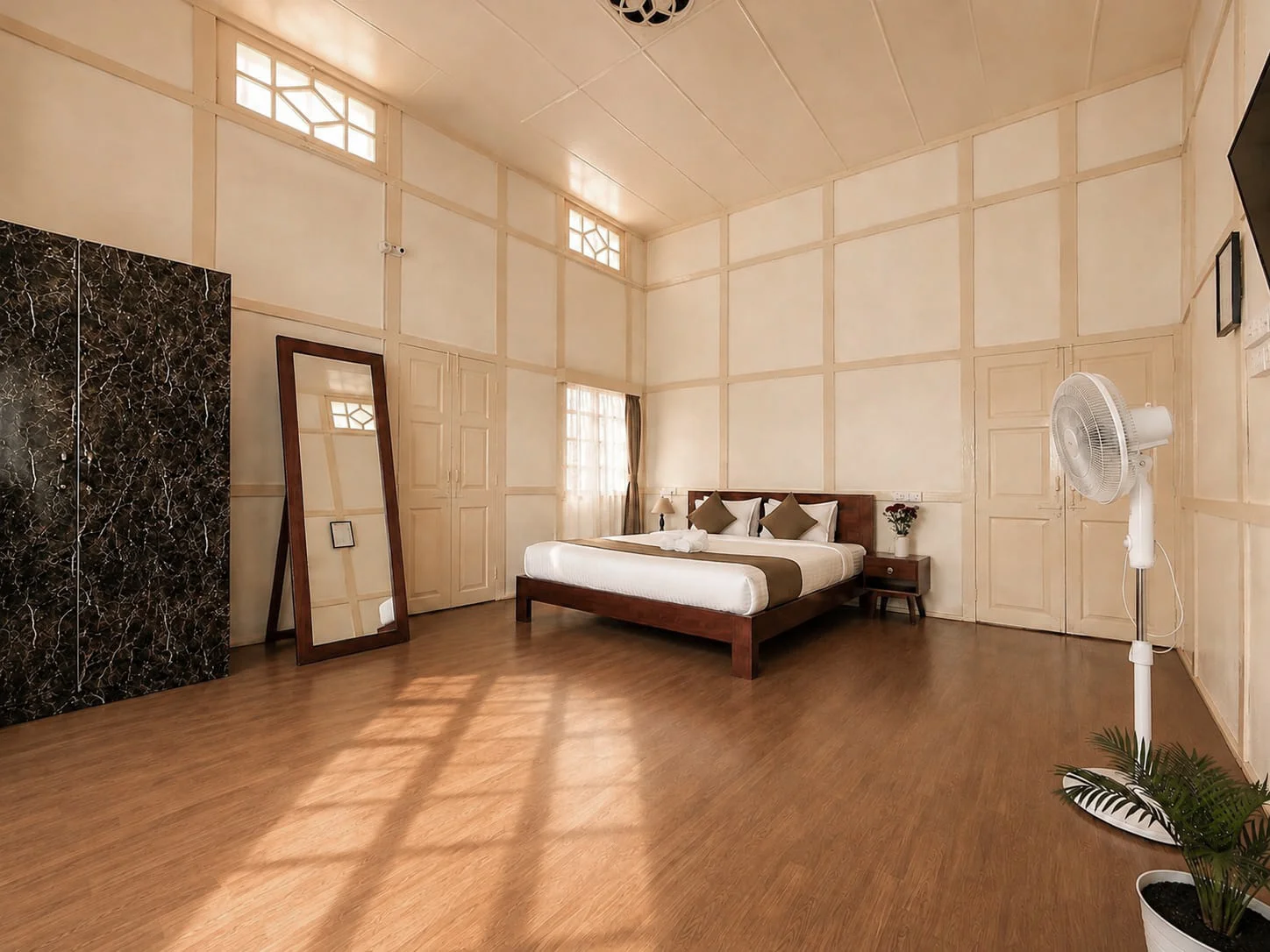 A wide view of Hometown Glory’s king bed and spacious cream-panelled room.