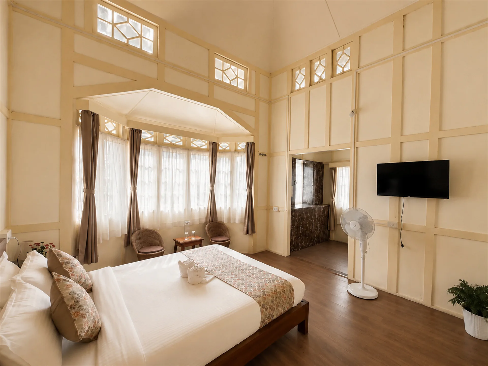 A side view of Vanilla Twilight with its bed, television and bay-window seating.