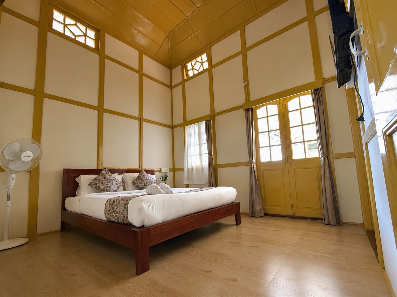A wide view of Yellow Haven’s bed and mustard timber detailing.